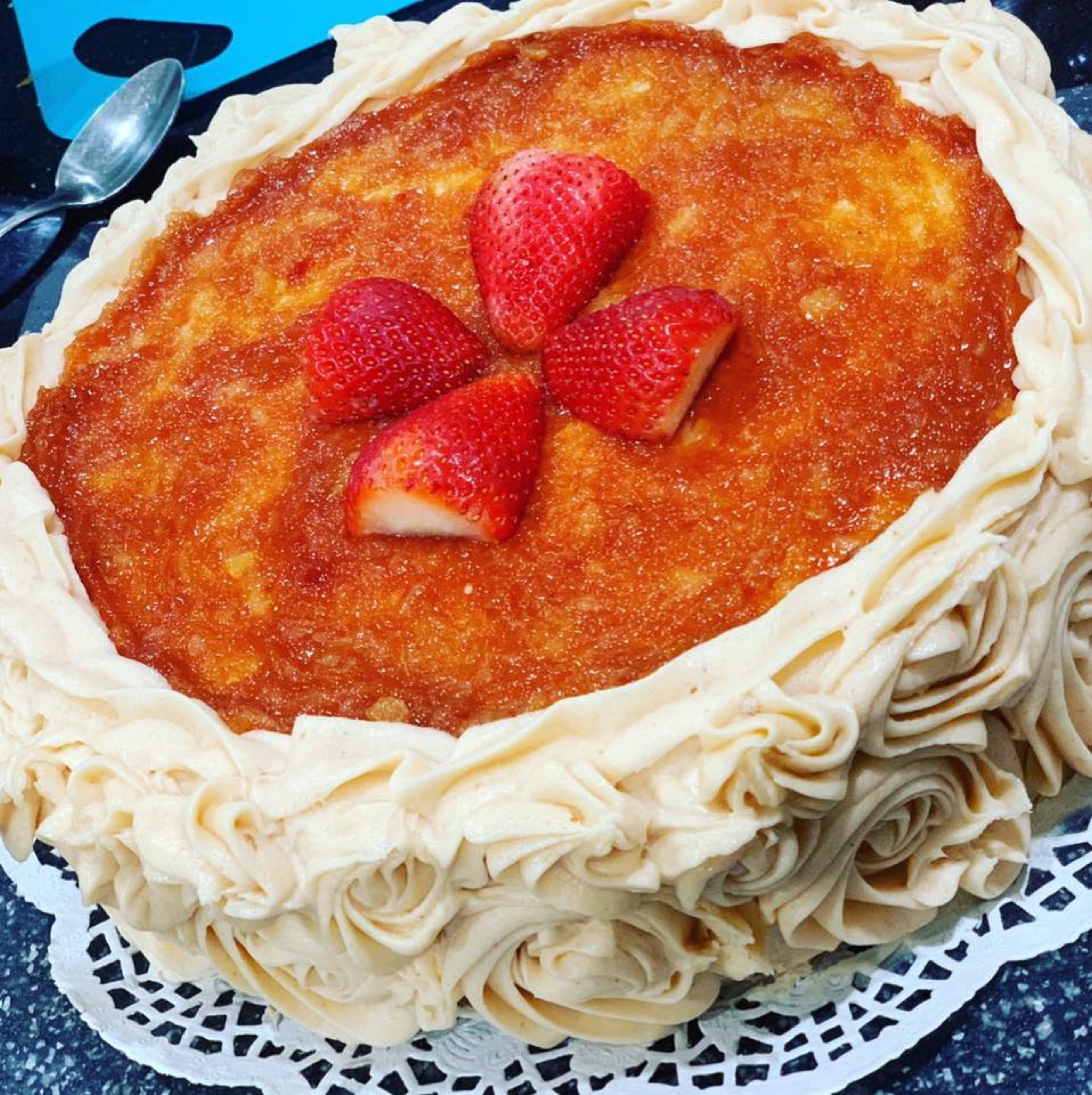 Flancocho dessert with caramel top, frosting border, and strawberries