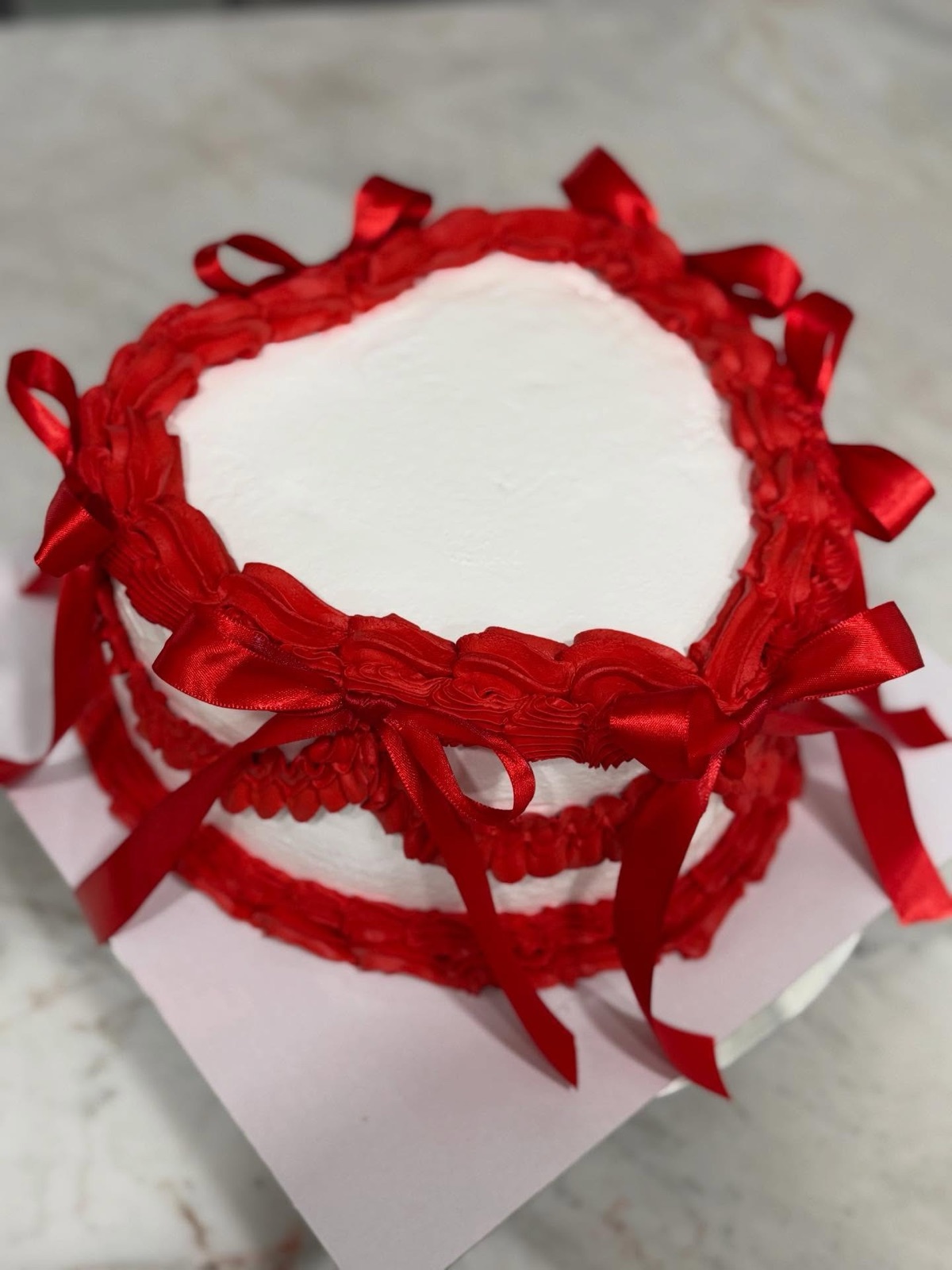 Red ribbon celebration cake for a seasonal dessert preorder
