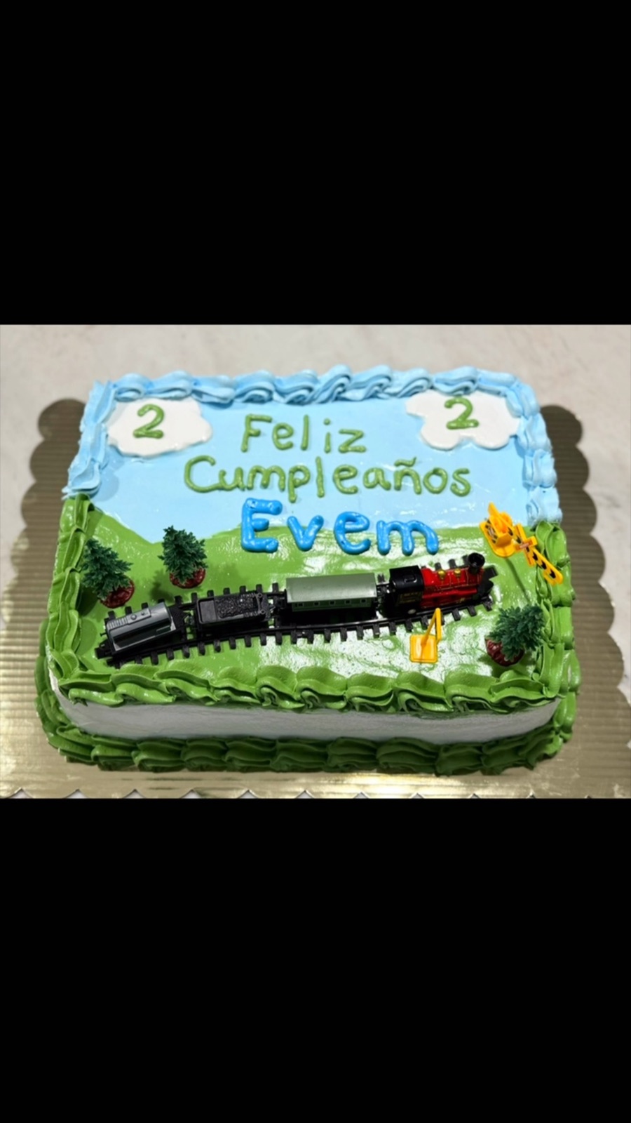 Train themed kids birthday cake with Spanish birthday message